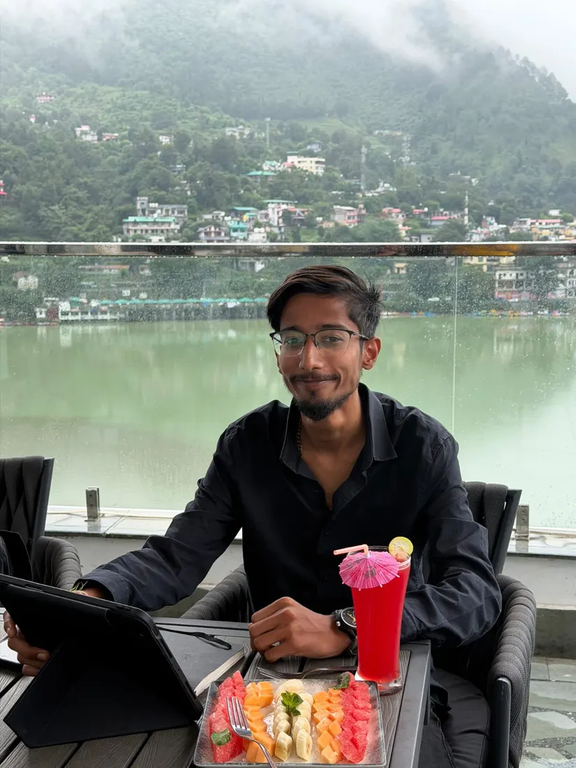 Sarwang Shukla working on a tablet by a lake